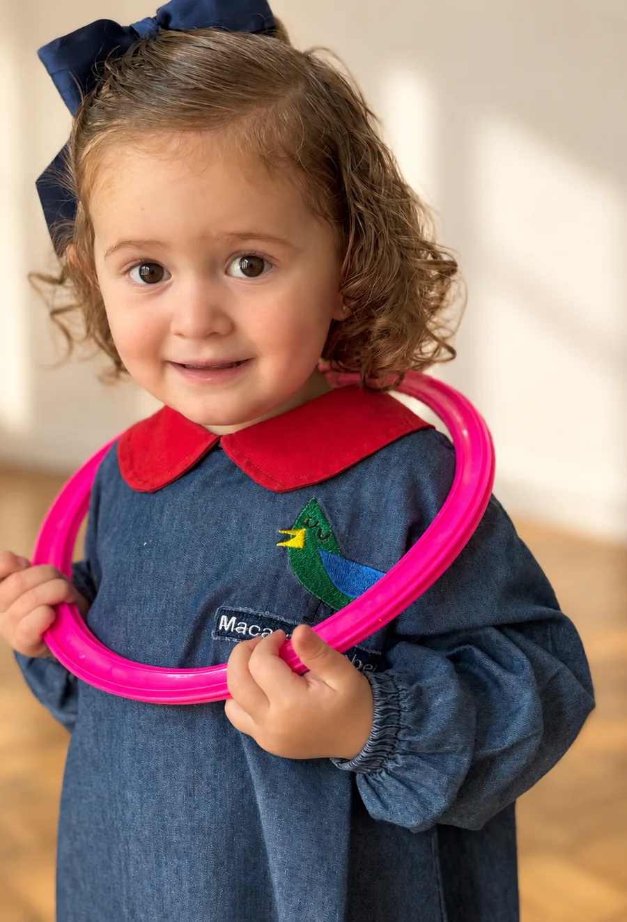 Niña de Pirulí sonriendo con un aro rosa